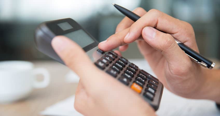 Accessible image showing elderly person using calculator and pen.