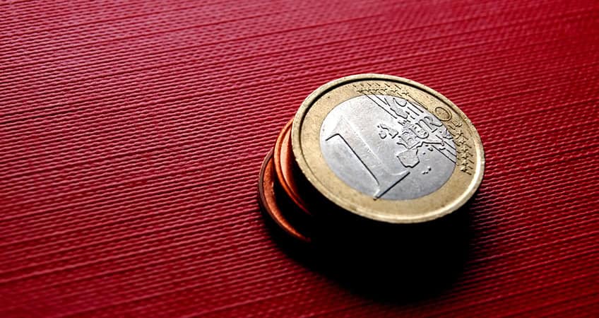 Euro coins on red surface for Irish seniors.