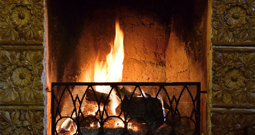 Fireplace with a warm fire, symbolising comfort for senior citizens.