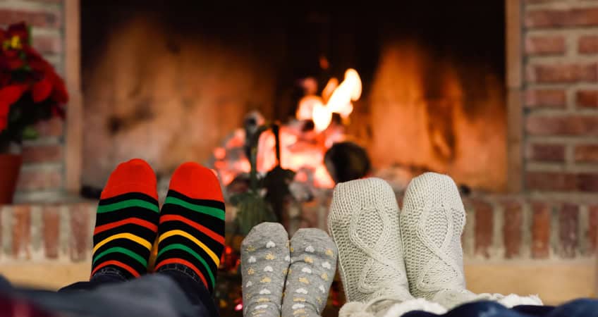 Warm feet near fireplace for seniors’ comfort and relaxation.