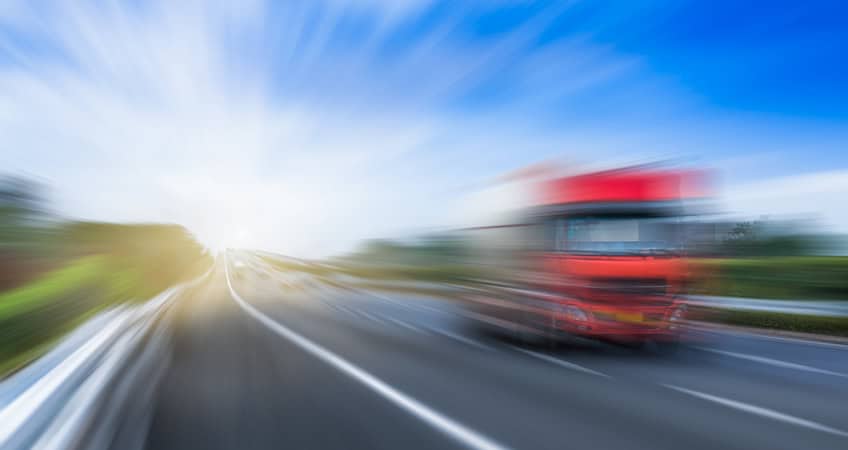 Blurred image of a red bus on a motorway, symbolising senior citizens' journey and community.