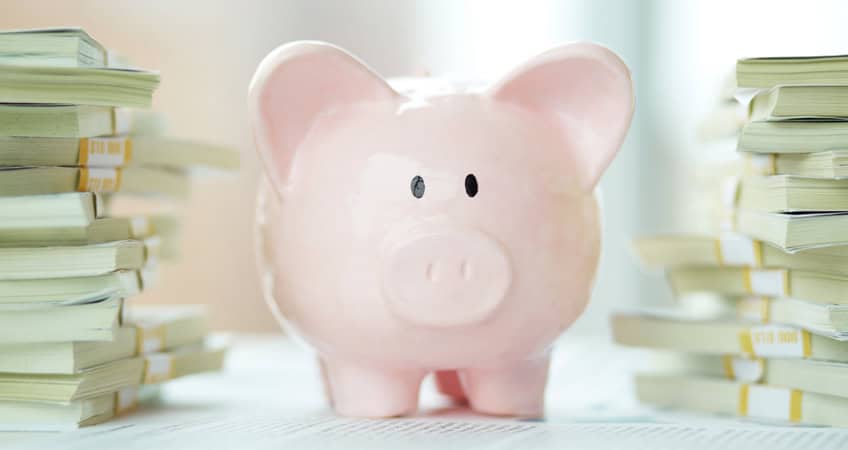 Piggy bank surrounded by stacks of documents, representing financial planning for Irish seniors.