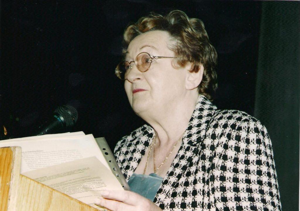 Elderly person speaking at Irish Senior Citizens Parliament event.