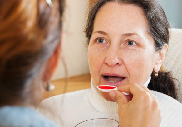 Older woman having health assessment at seniors' community event.