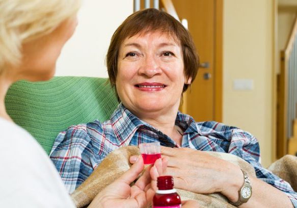Older woman receiving medical care at home, showing support for Irish senior citizens.