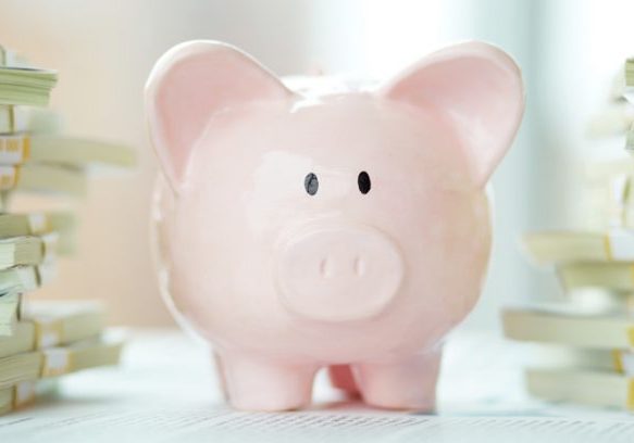 Piggy bank surrounded by stacks of documents, representing financial planning for Irish seniors.