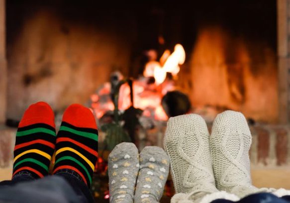 Warm feet near fireplace for seniors’ comfort and relaxation.